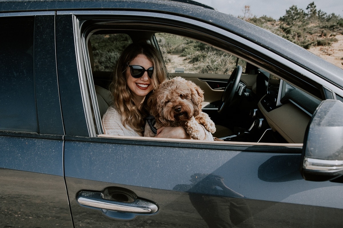 Roadtrip on the Algarve: a woman with a dog in a car